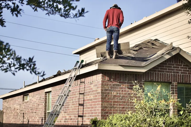 Professional roofer working on a residential roof in American Village